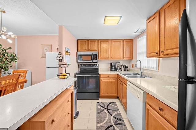 kitchen featuring black appliances, sink, hanging light fixtures, light tile patterned floors, and a notable chandelier