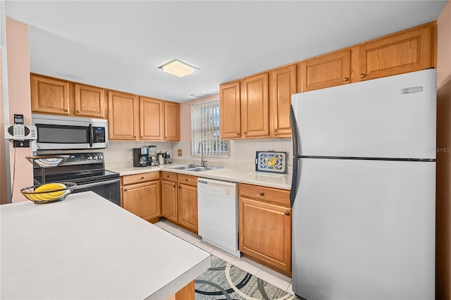 kitchen with light tile patterned floors, white appliances, and sink