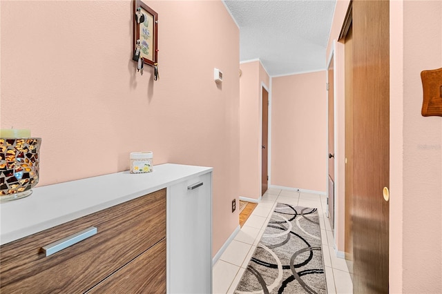 corridor featuring light tile patterned floors and a textured ceiling