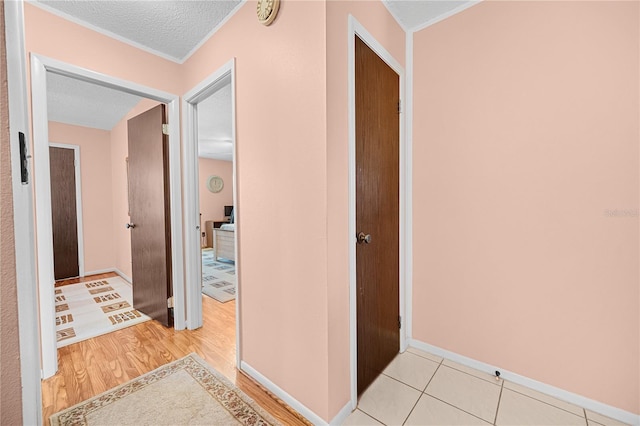 hall featuring light hardwood / wood-style floors and a textured ceiling