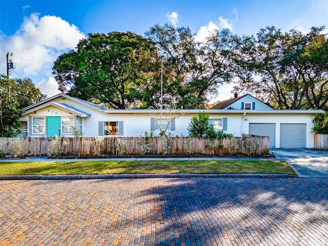 ranch-style house with a garage and a front lawn