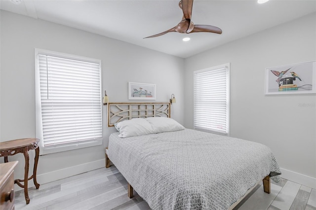 bedroom with multiple windows, ceiling fan, and light hardwood / wood-style floors