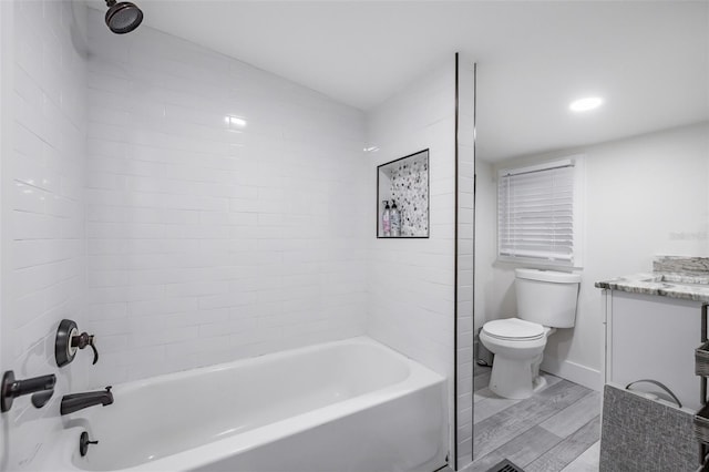 full bathroom with toilet, vanity, and tiled shower / bath