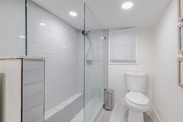 bathroom with tiled shower and toilet