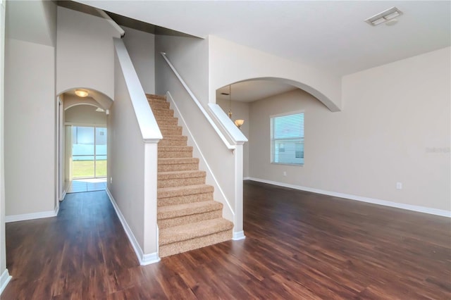 staircase featuring hardwood / wood-style flooring and a chandelier