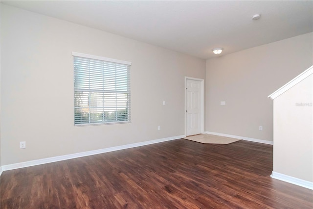 unfurnished room with dark wood-type flooring