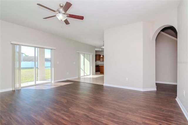 unfurnished room with a water view, ceiling fan, and dark hardwood / wood-style floors