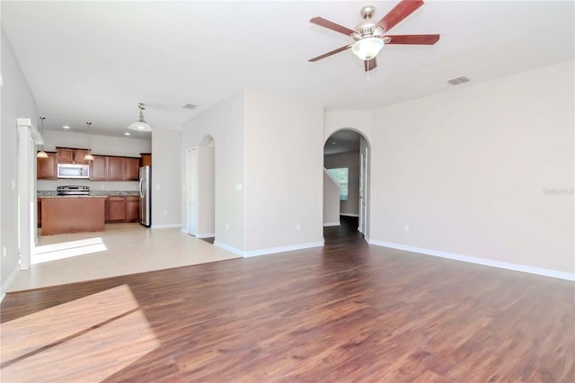 unfurnished living room featuring light hardwood / wood-style flooring and ceiling fan