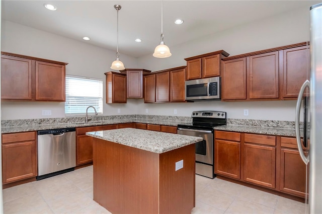 kitchen with light stone countertops, appliances with stainless steel finishes, sink, a center island, and hanging light fixtures