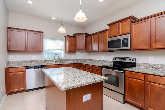 kitchen featuring light stone countertops, appliances with stainless steel finishes, sink, a kitchen island, and hanging light fixtures