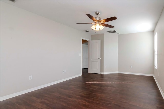 spare room with ceiling fan, plenty of natural light, and dark wood-type flooring