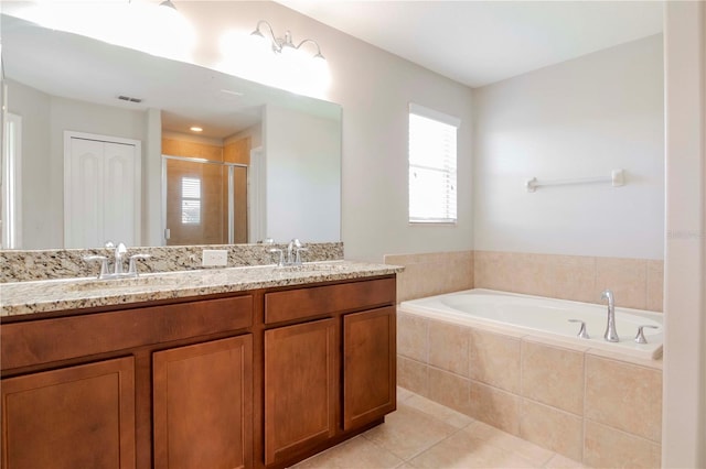 bathroom featuring tile patterned flooring, shower with separate bathtub, and vanity