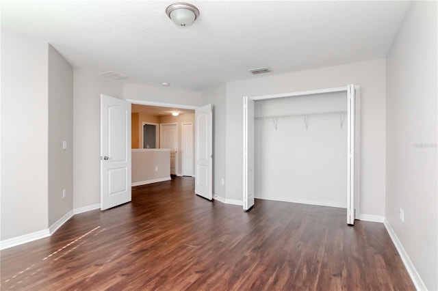 unfurnished bedroom featuring dark hardwood / wood-style flooring and a closet