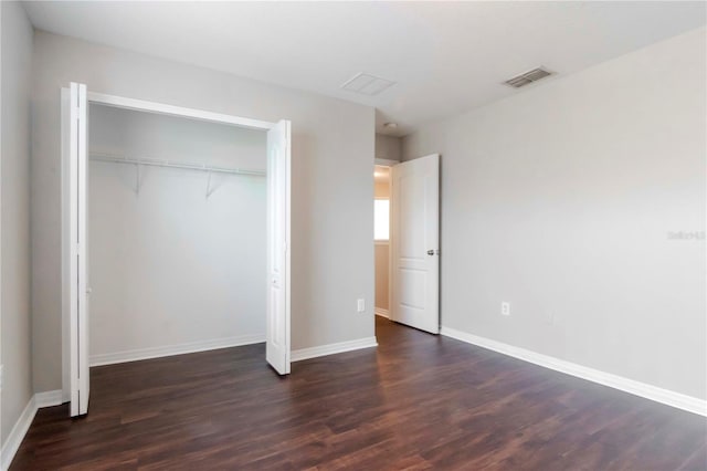 unfurnished bedroom with dark hardwood / wood-style floors and a closet