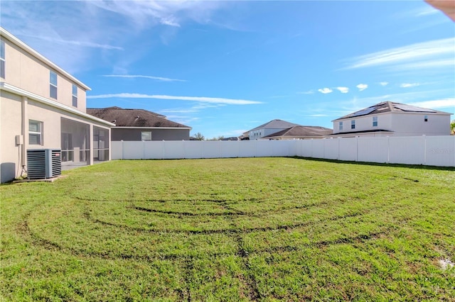 view of yard featuring a sunroom and central AC