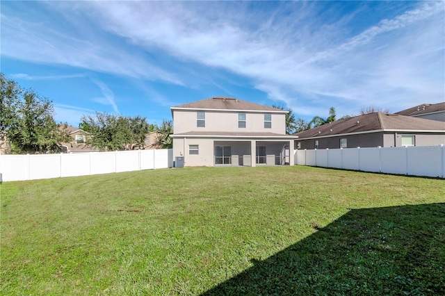 rear view of house featuring a lawn and cooling unit