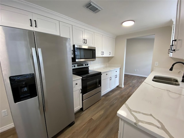 kitchen with light stone countertops, sink, white cabinets, and stainless steel appliances