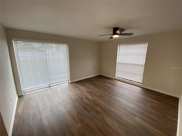 spare room featuring ceiling fan and dark wood-type flooring