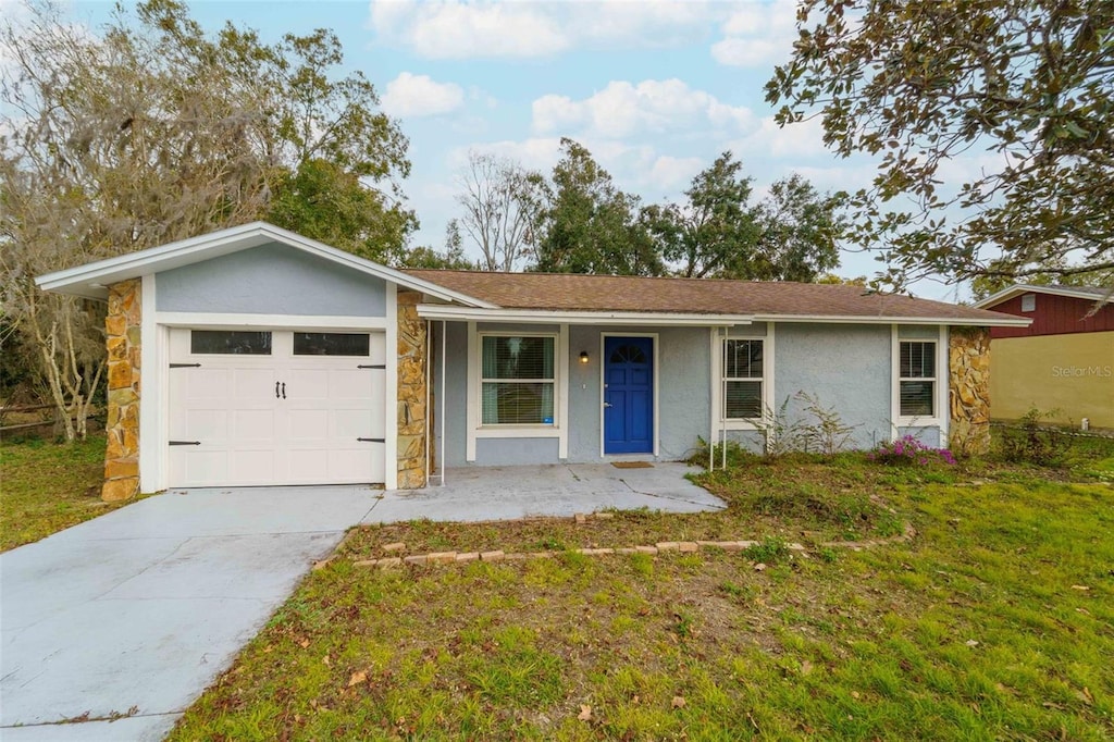 ranch-style house featuring covered porch, a garage, and a front yard