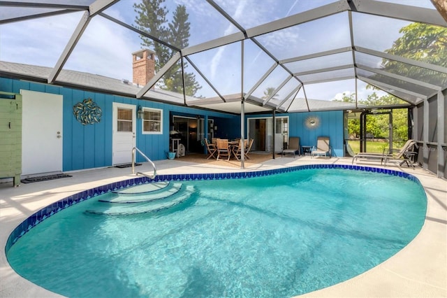 view of pool featuring glass enclosure and a patio