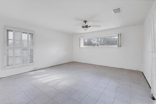 tiled empty room featuring ceiling fan