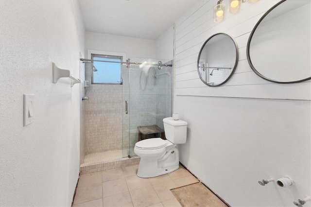 bathroom with tile patterned flooring, a shower with door, and toilet