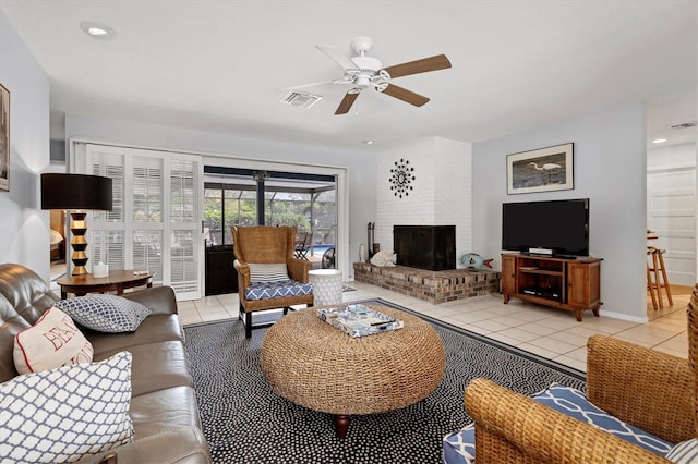 living room with ceiling fan, light tile patterned flooring, and a brick fireplace