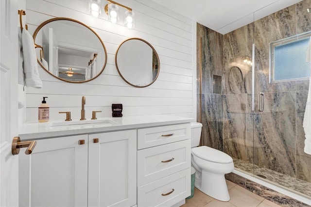 bathroom featuring tile patterned flooring, wood walls, an enclosed shower, toilet, and vanity