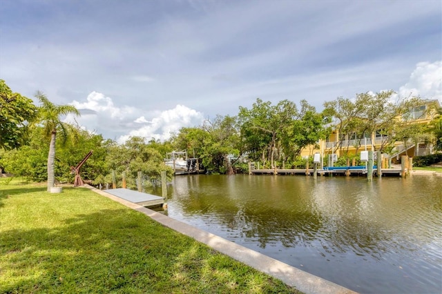 view of dock featuring a water view and a yard