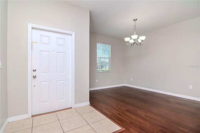 tiled entrance foyer featuring an inviting chandelier