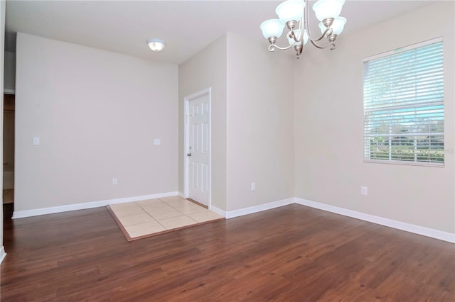 spare room featuring an inviting chandelier and light hardwood / wood-style flooring