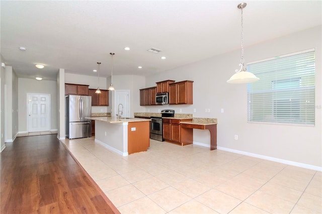 kitchen featuring decorative light fixtures, sink, a kitchen island with sink, and appliances with stainless steel finishes