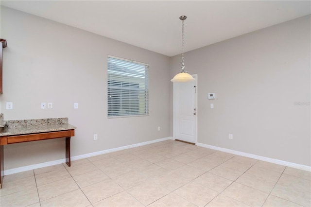 unfurnished dining area featuring light tile patterned floors