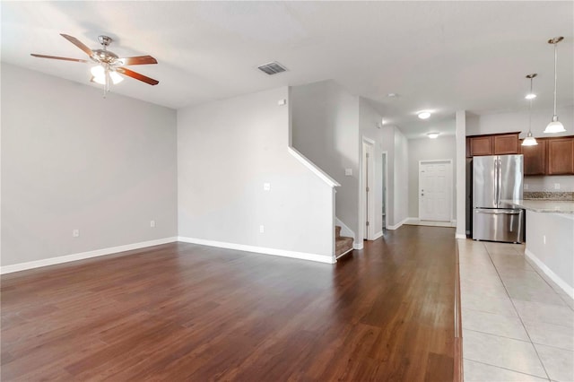 unfurnished living room with ceiling fan and dark wood-type flooring