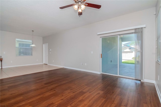 unfurnished living room featuring ceiling fan and dark wood-type flooring