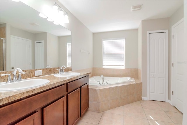 bathroom featuring vanity, tiled bath, and tile patterned floors