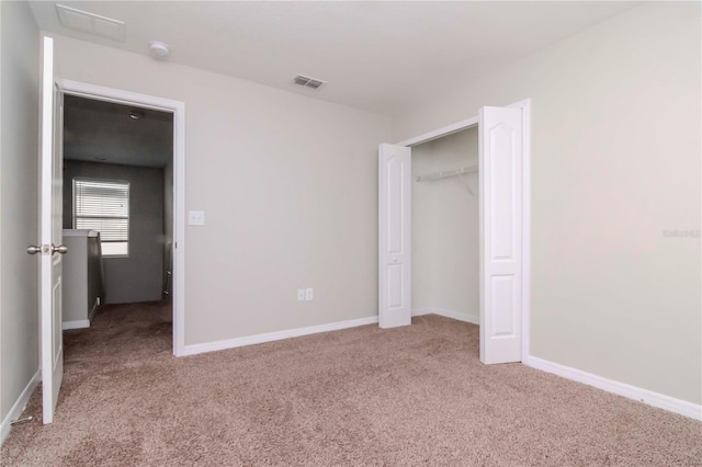 unfurnished bedroom with light carpet and a closet