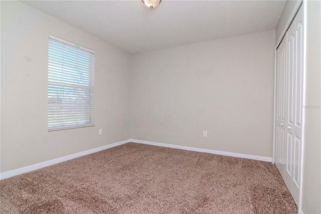 unfurnished bedroom with carpet flooring, multiple windows, and a closet