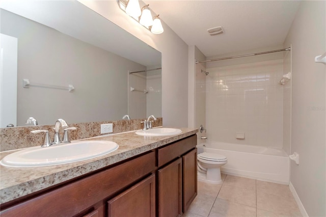 full bathroom with tile patterned flooring, vanity, tiled shower / bath combo, and toilet