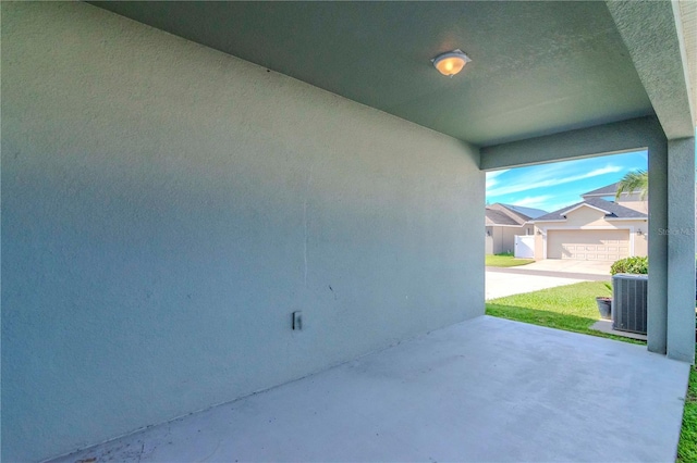 view of patio with central AC unit and a garage