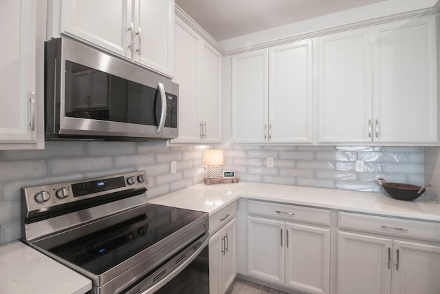 kitchen with decorative backsplash, white cabinetry, and stainless steel appliances