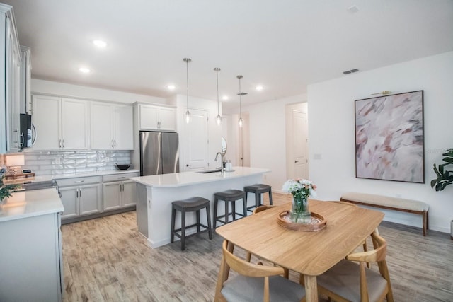 dining space with sink and light wood-type flooring