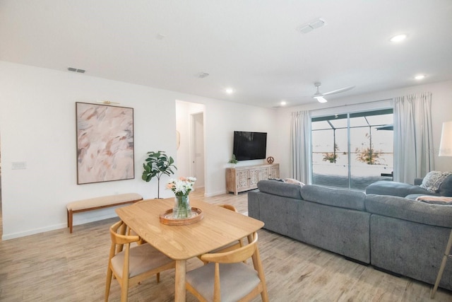 living room with ceiling fan and light hardwood / wood-style flooring