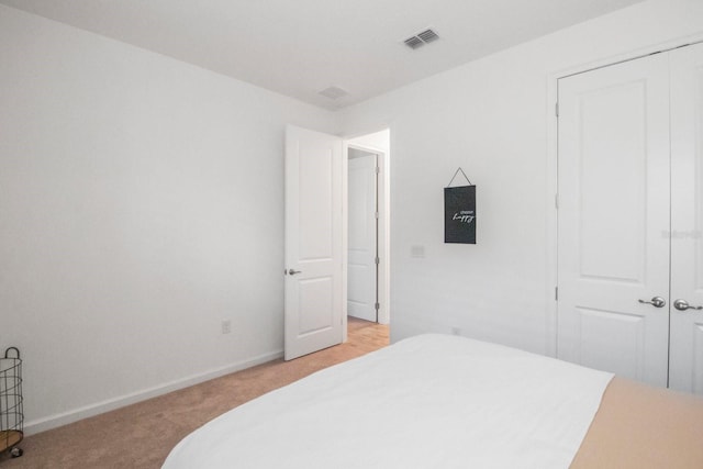 bedroom with light colored carpet and a closet