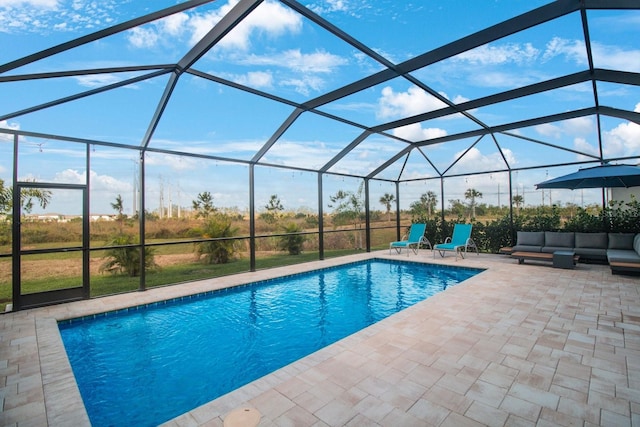 view of swimming pool featuring glass enclosure, an outdoor living space, and a patio