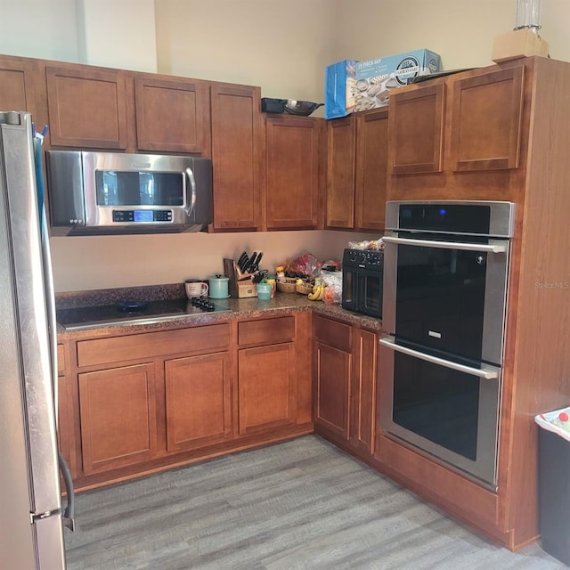 kitchen with stainless steel appliances and light hardwood / wood-style floors