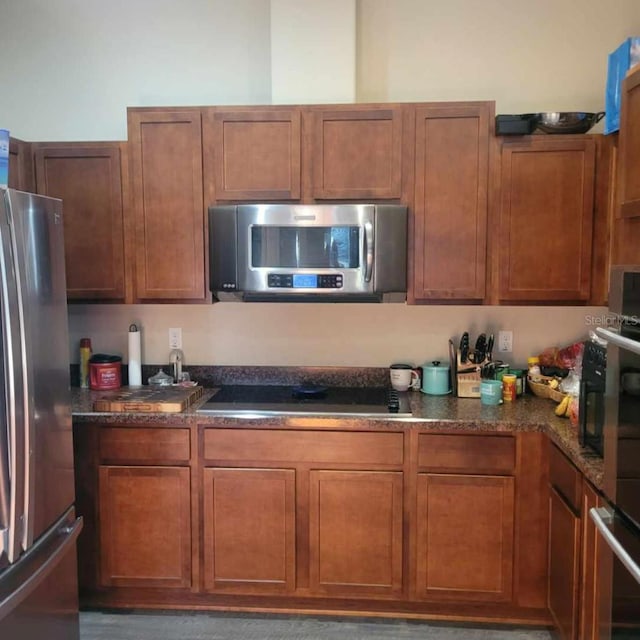 kitchen with stainless steel appliances and dark stone counters