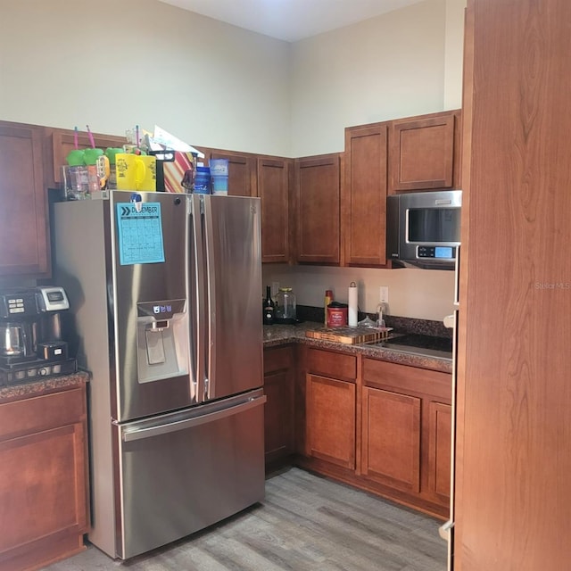 kitchen with stovetop, light hardwood / wood-style floors, and stainless steel fridge with ice dispenser