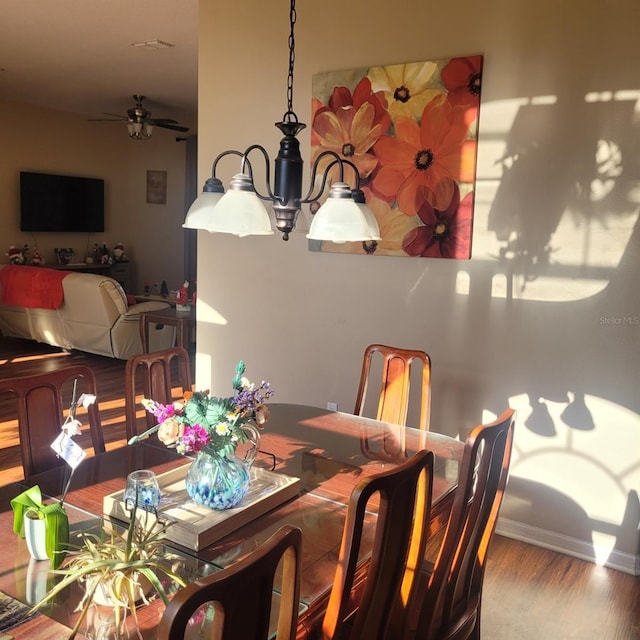 dining area featuring hardwood / wood-style flooring and ceiling fan with notable chandelier