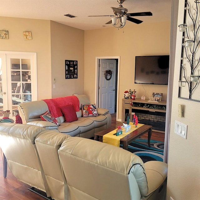 living room with hardwood / wood-style floors, a textured ceiling, and ceiling fan